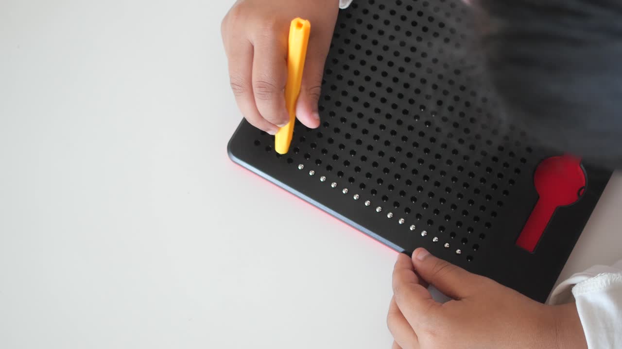 Child playing with a magnetic drawing board