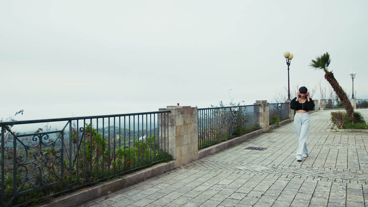 Woman Slowly Walking In The Italian Town Streets Listening To Music