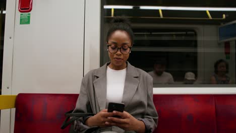 woman using smartphone on a subway train