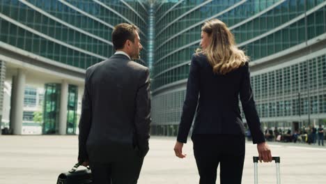 cinematic shot of happy smiling business colleagues in formal apparel are walking satisfied with their work after leaving the offices. concept of corporate, company, success, cooperation, teamwork.