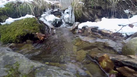 a small river flowing through the first snow