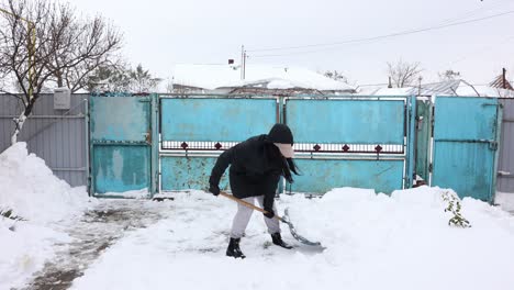 Woman-Clearing-Snow-With-Shovel-During-Winter---wide
