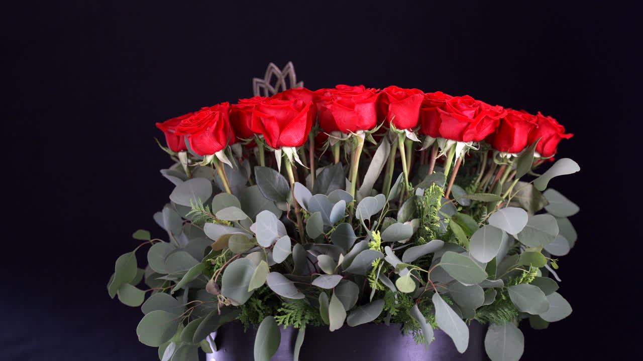 Composizione di rose rosse che ruota con decorazione a loto su sfondo nero
