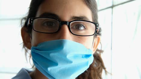 portrait close up female doctor puts on protective face mask