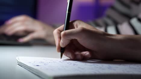 macro footage of man tracing a schema and a woman typing on keyboard on the background
