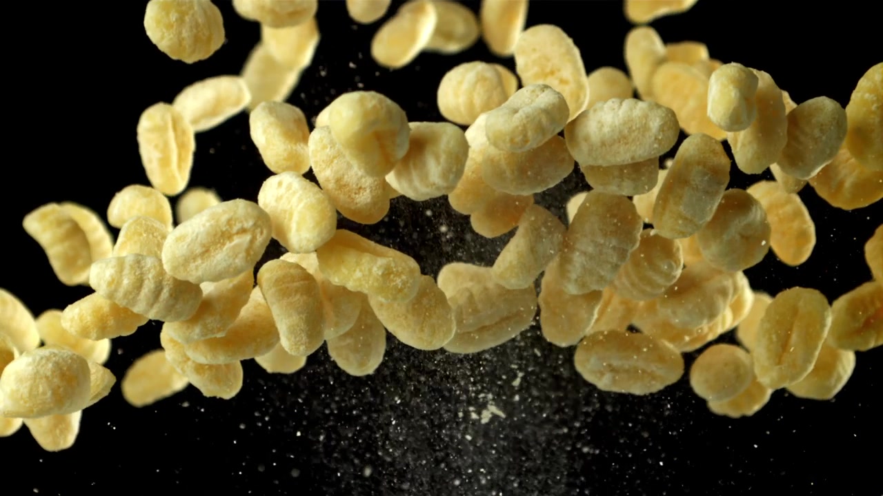 Fresh Gnocchi Pasta Falling in Slow Motion Against Black Background