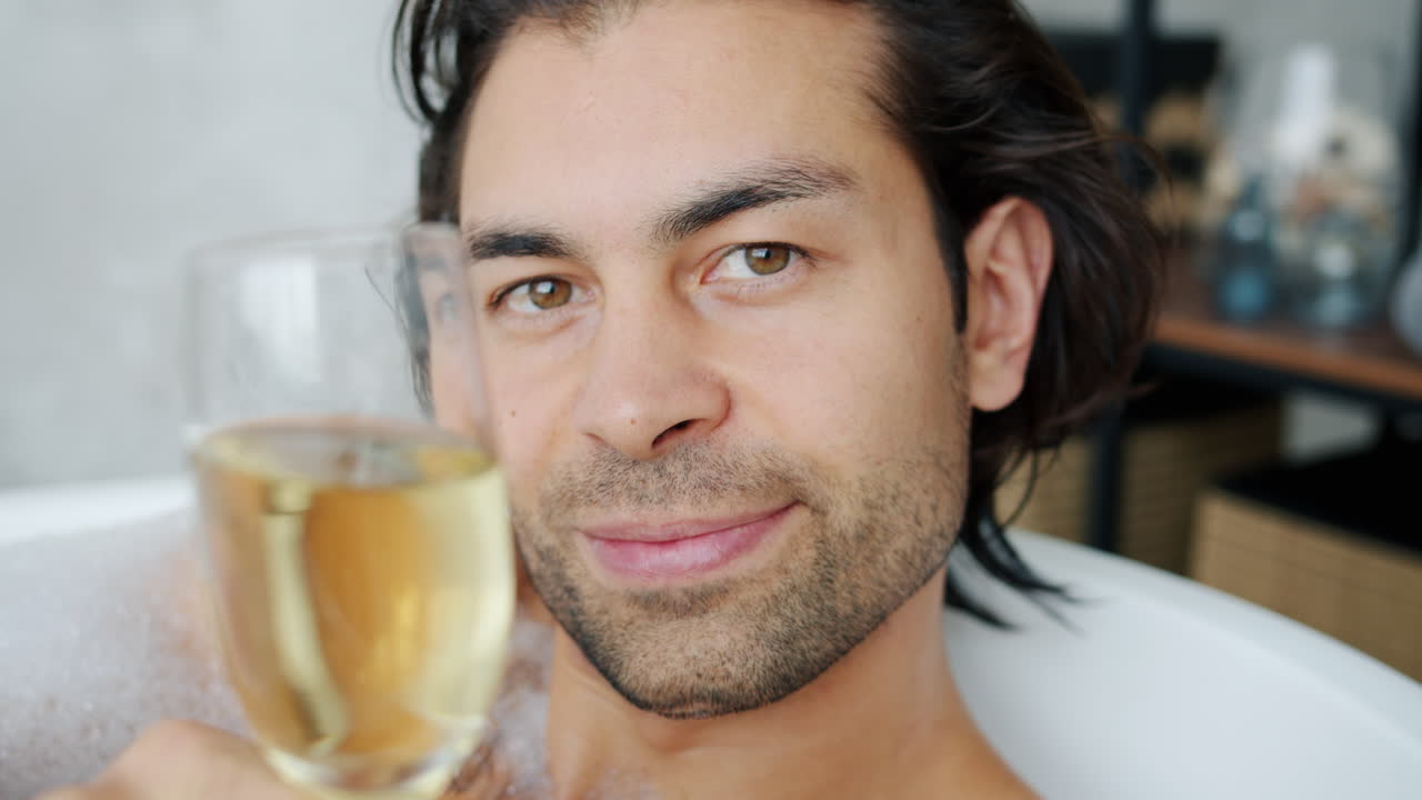 Man Drinking Champagne in a Bathtub