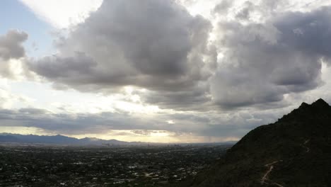 tilting shot down from stormy clouds to reveal scottsdale, arizona and camelback mountain