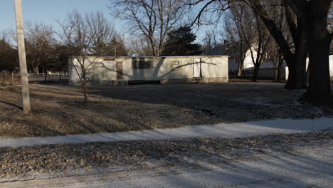 camera pans into a broken down trailer house owned by a low income family in poverty