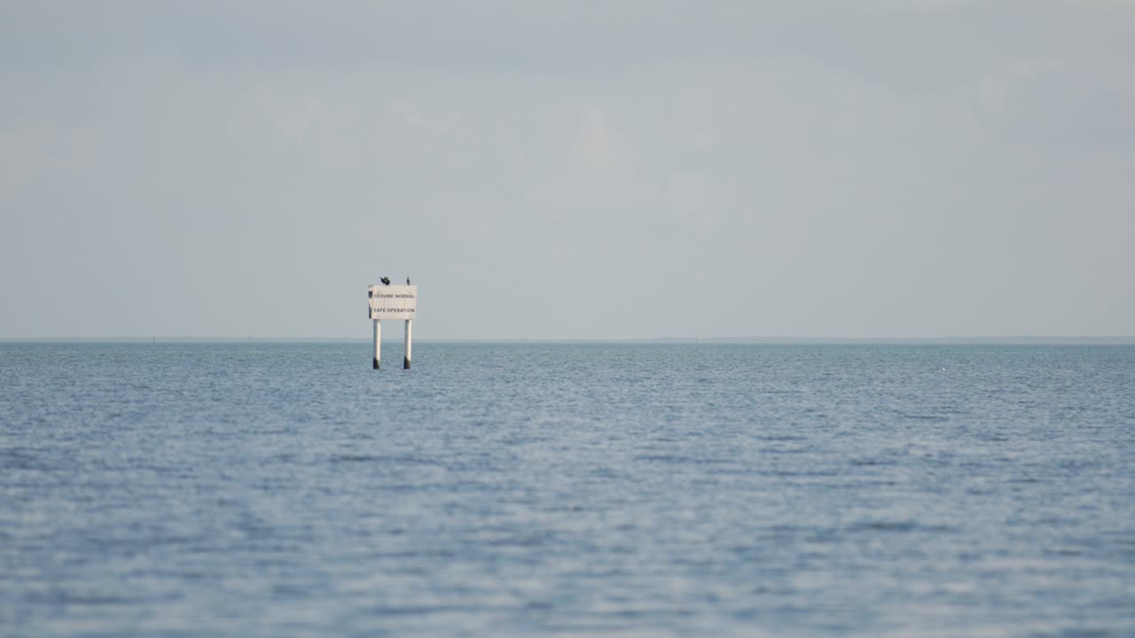 Ripresa al rallentatore di un segnale di navigazione nell'oceano vicino al Biscayne National Park, Florida. Le acque calme e il cielo terso lo rendono ideale per progetti marittimi, nautici o di navigazione.