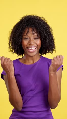 ecstatic woman celebrating triumph against yellow background