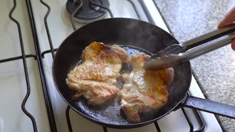 searing succulent chicken in a pan of hot cooking oil