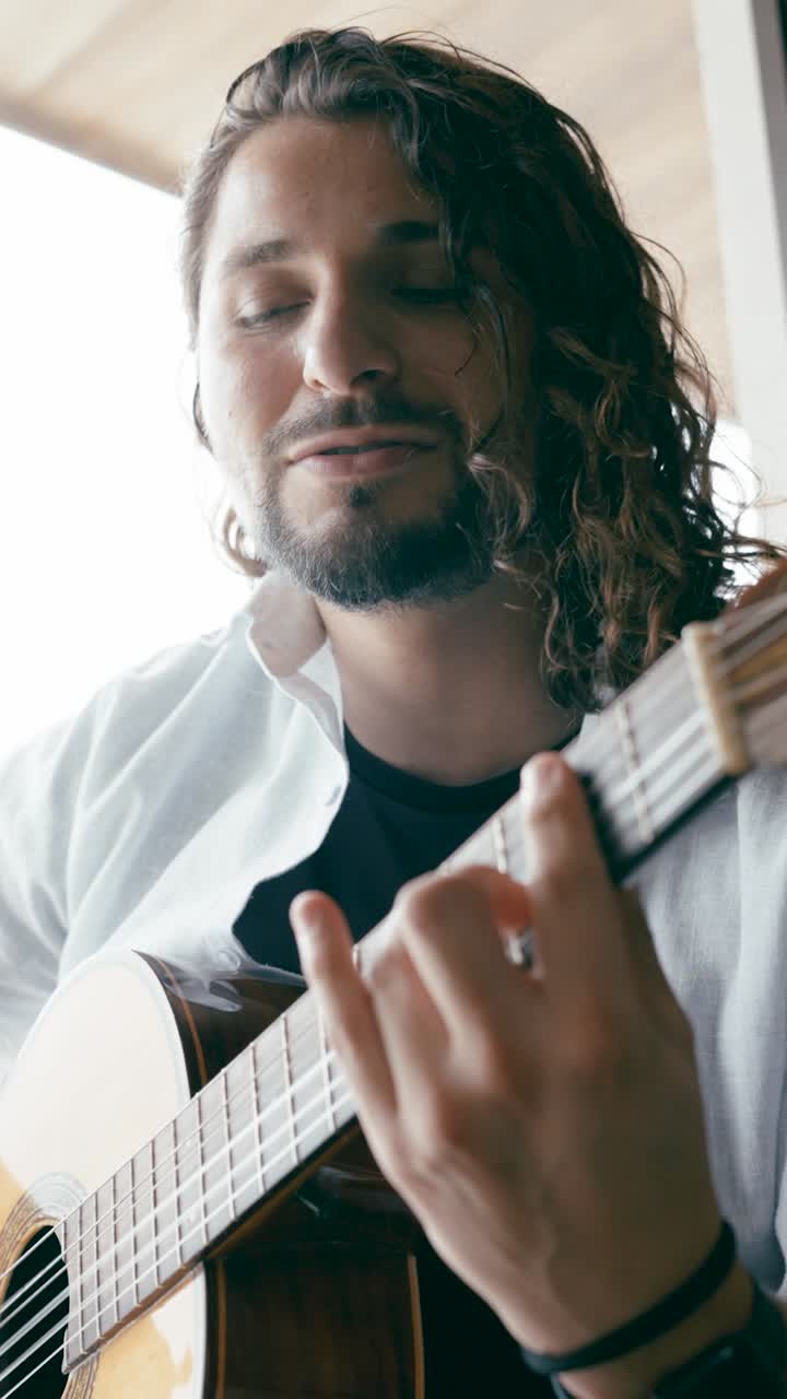 hombre tocando la guitarra acústica