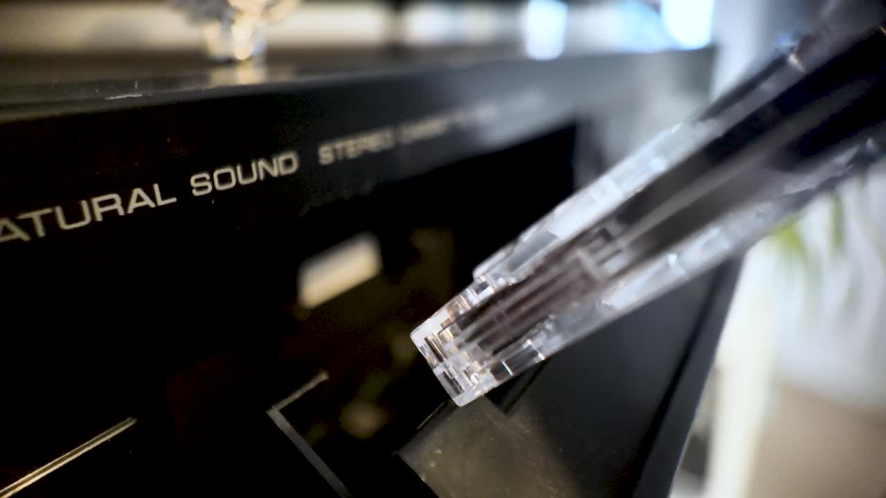 Hand inserting audio cassette tape into a retro stereo hifi sound system