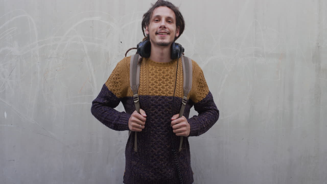 retrato relajado joven de raza mixta se quita los auriculares sonriendo confiado disfrutando de un estilo de vida exitoso satisfacción