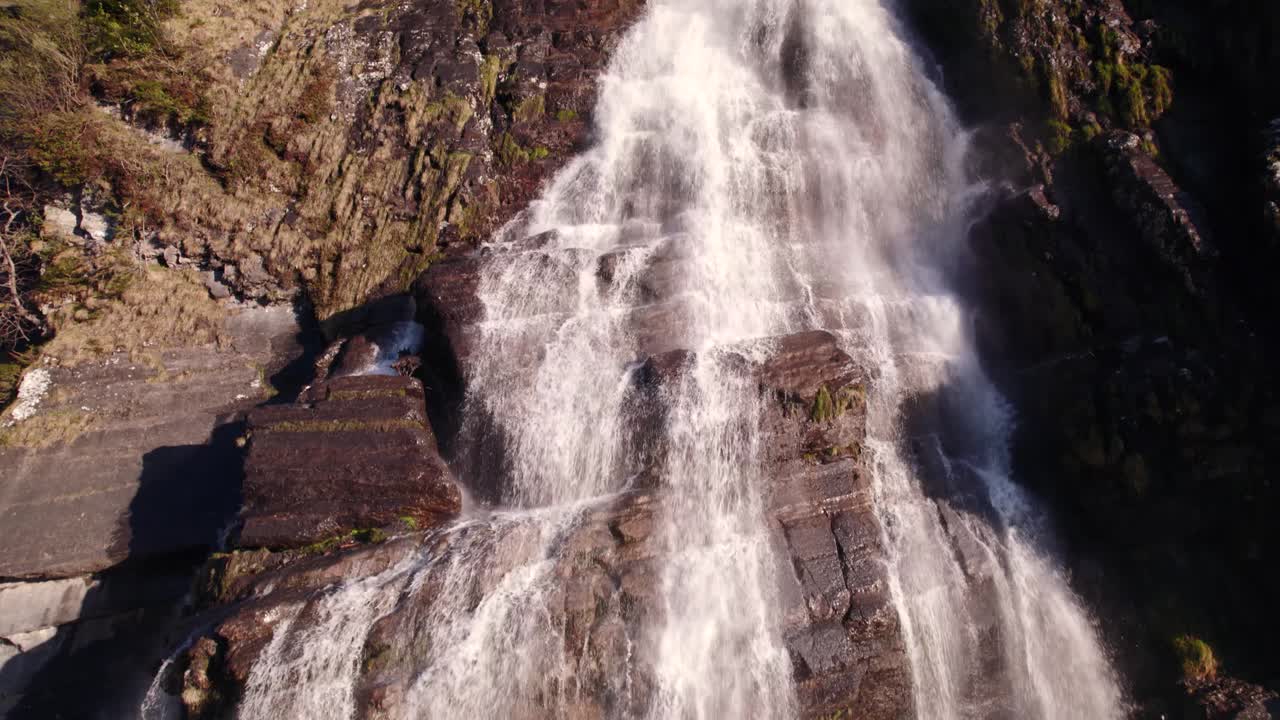 imágenes aéreas de drones levantando una pintoresca cascada en primavera con coloridos reflejos de luz en fallbach en grindelwald en suiza