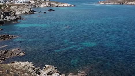 aerial drone moving forward along cliffside beach