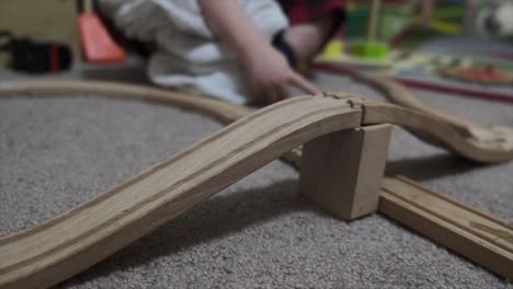 Un-Niño-Pequeño-Y-Un-Padre-Jugando-Juntos-Con-Un-Tren-De-Madera