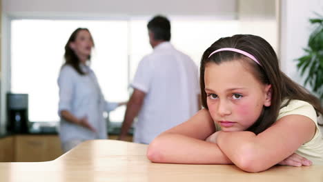 una niña escuchando a sus padres peleando