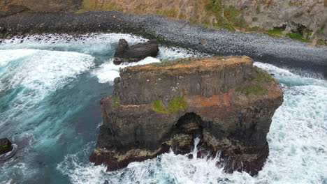 volando sobre la formación volcánica ubicada en la playa de los rocas en la isla de tenerife y en un día soleado
