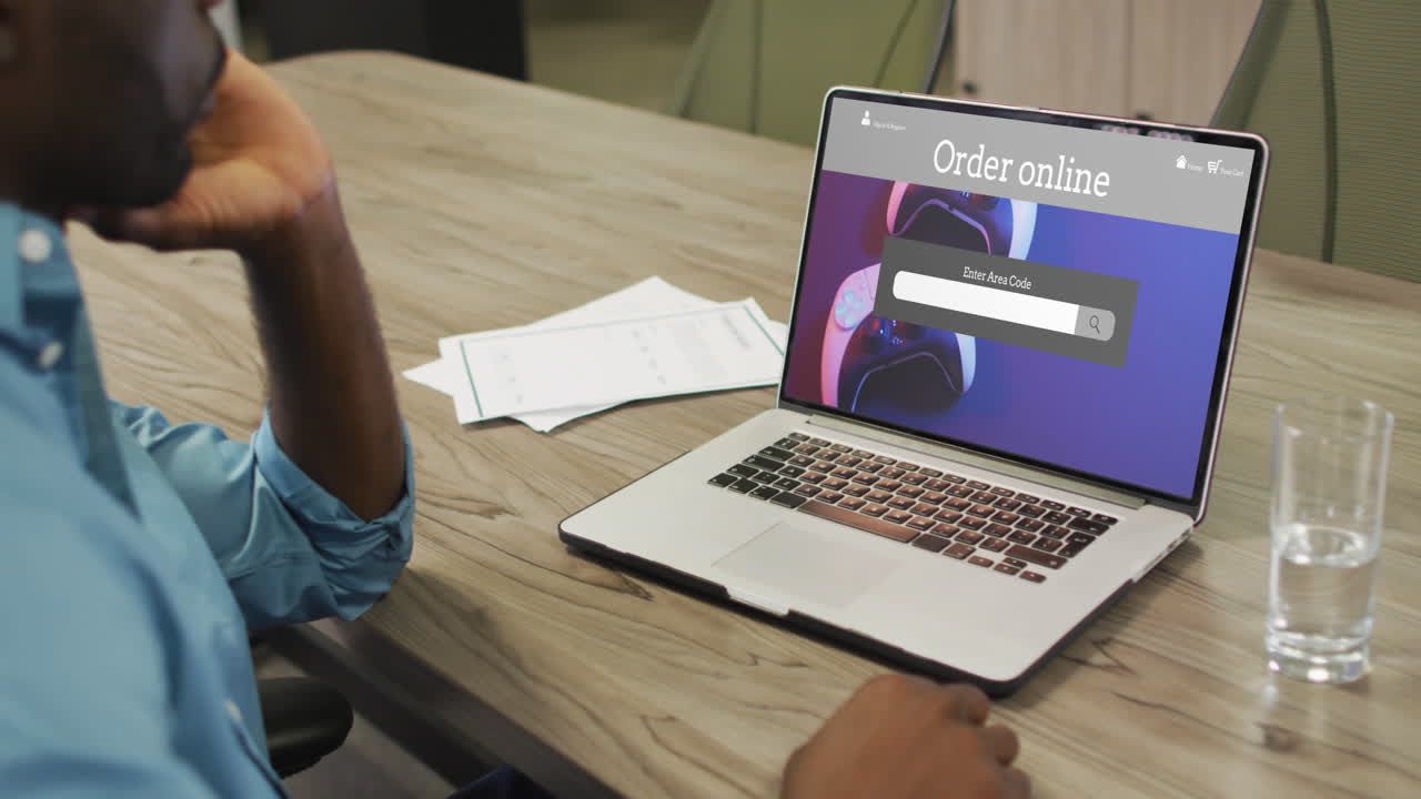 hombre afroamericano usando portátil, compras en línea para gamepads, cámara lenta