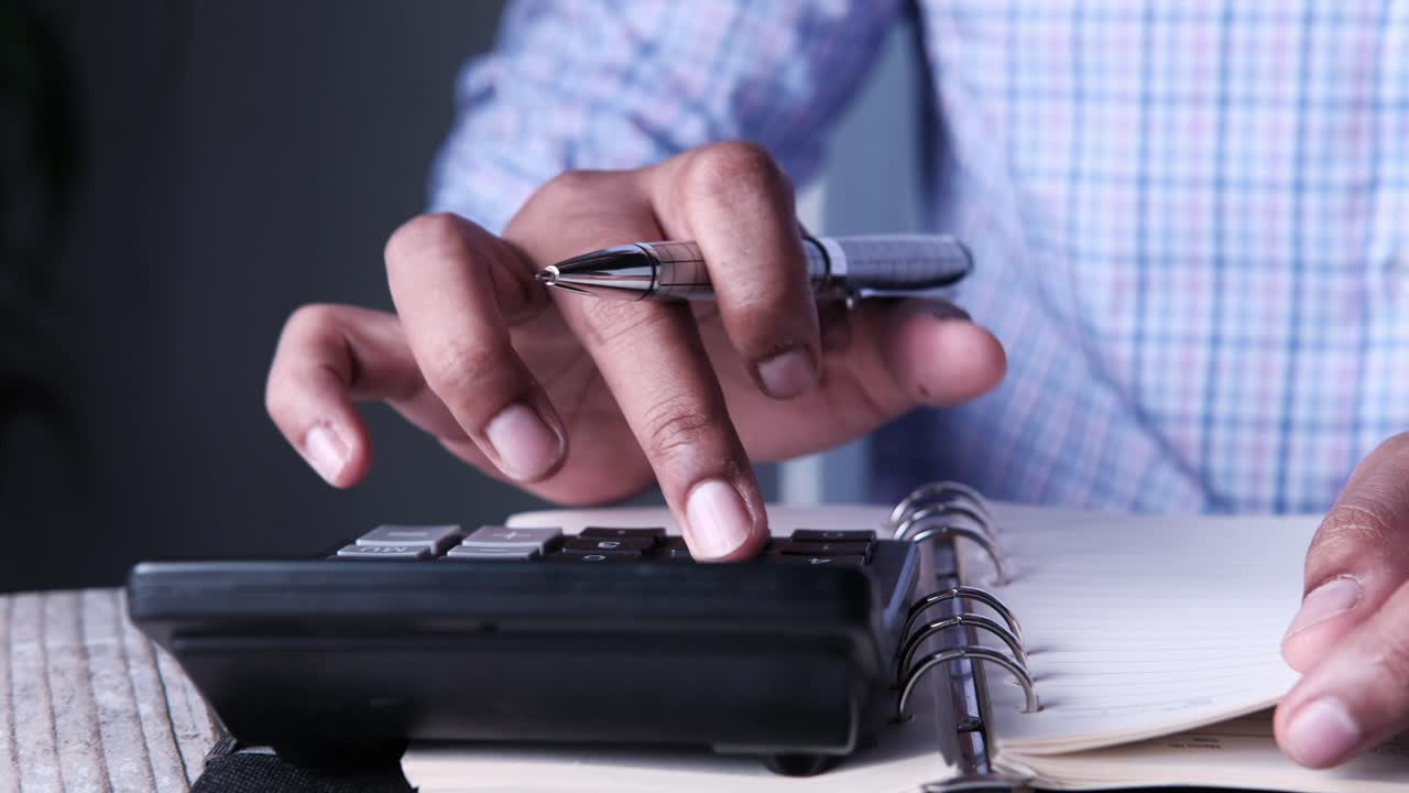 persona que utiliza una calculadora y un portátil