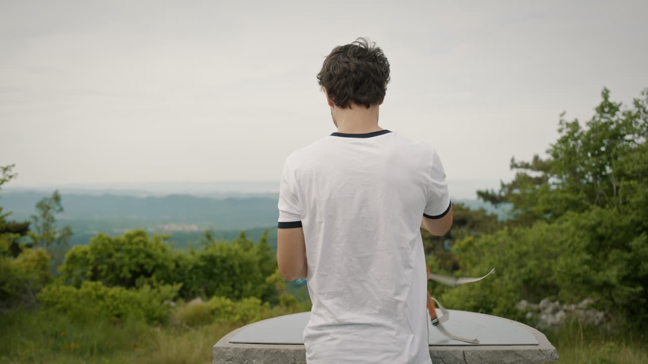 등산객은 방향이 적힌 원형 테이블이 있는 산 정상에 도달합니다.