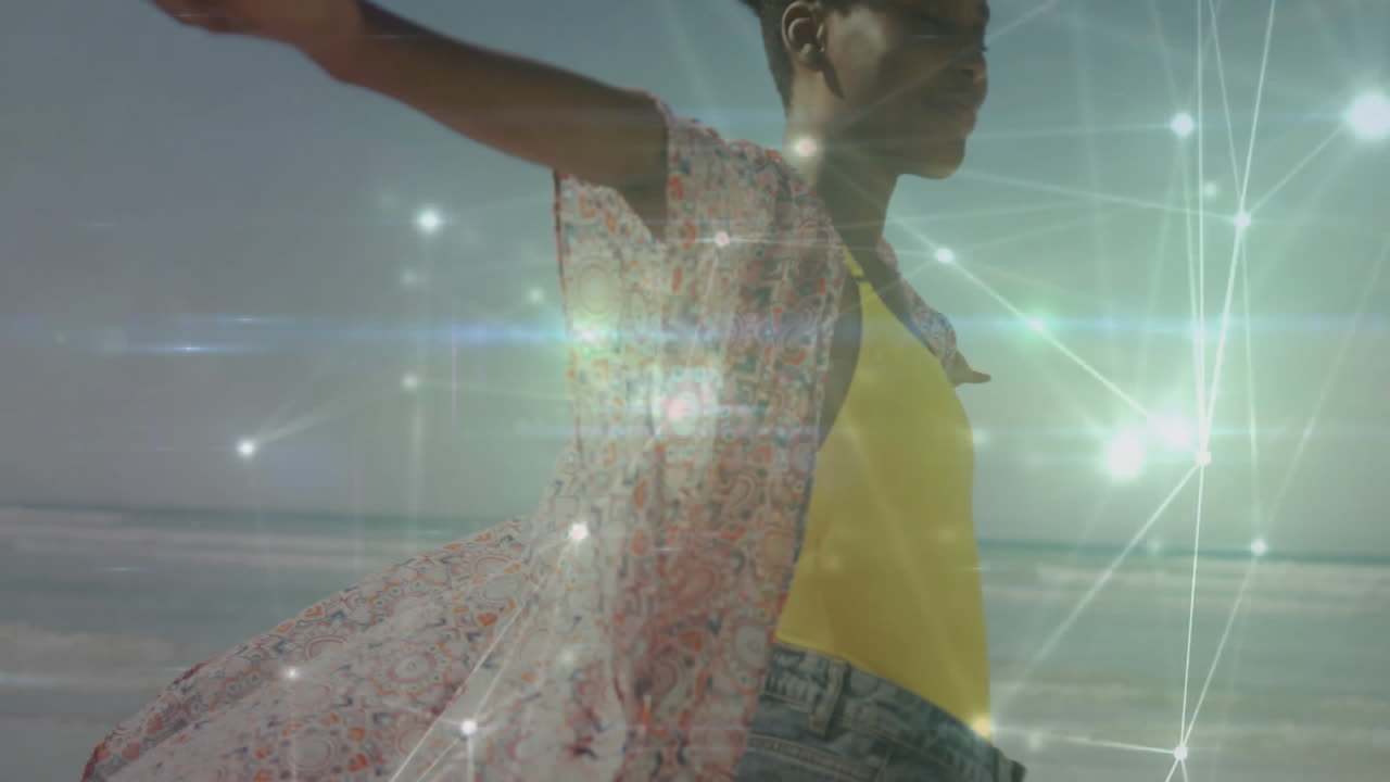 woman balancing on beach, displaying colorful shawl, floating network lines showing tech connection