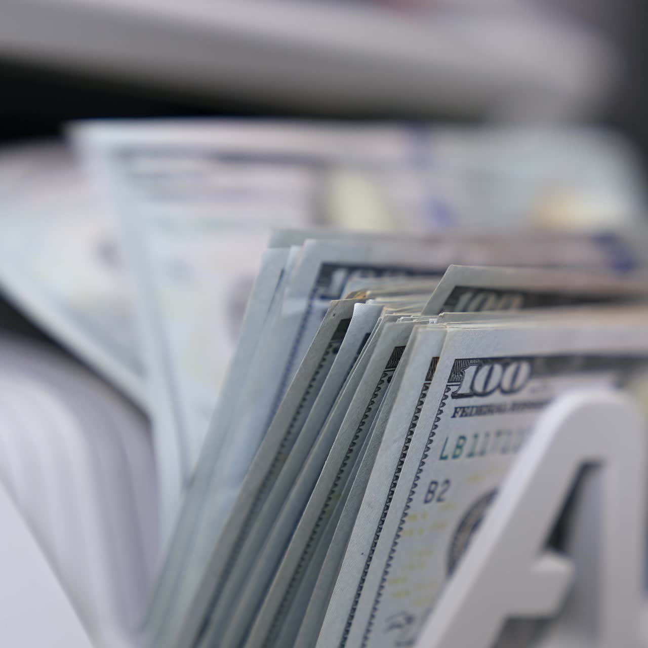 Macchina contabanote in primo piano. Un mucchio di banconote americane. La valuta mondiale è il dollaro USA.