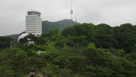 Aerial-shot-of-Namsan-park-with-a-view-of-Seoul-tower-and-mountain,-South-Korea