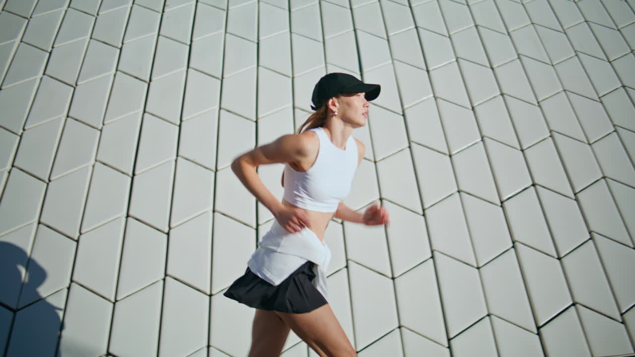 Woman runner start training at sunny street wearing sportswear. Lady running