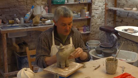 potter working on clay sculpture