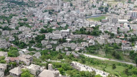 Drohnenansicht-In-Albanien,-Die-In-Gjirokaster-über-Eine-Mittelalterliche-Stadt-Fliegt-Und-Die-Ziegelbraunen-Dachhäuser-Zeigt