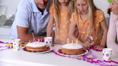 Twin-sisters-blowing-out-candles