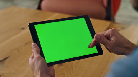 man finger swiping greenscreen tablet office. close up specialist scrolling tab