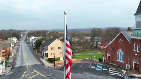 aerial shot of an american flag outside a brick church