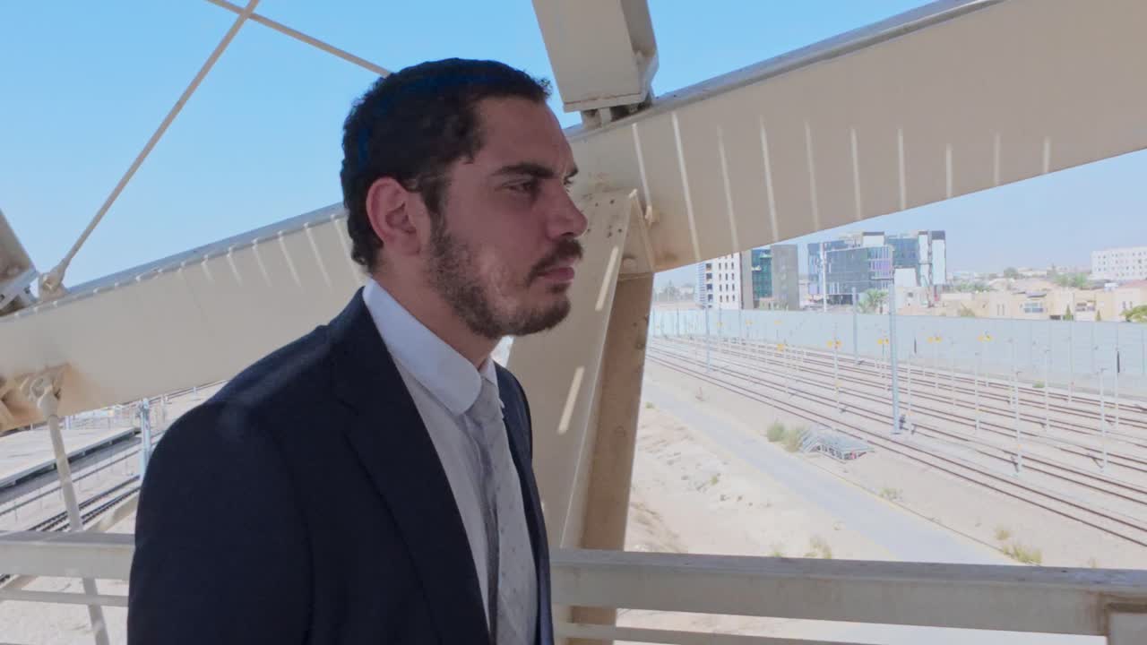 Perfil lateral de un hombre de negocios serio mirando la ciudad desde un puente