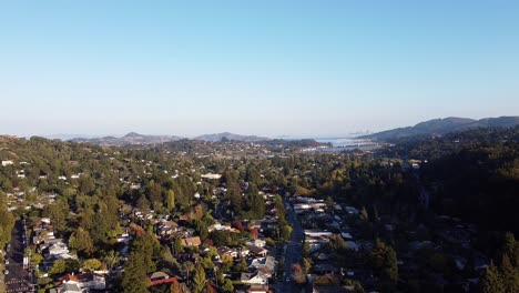 aerial view of a quiet and wooded town in the hills and mountains on a sunny day