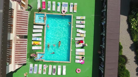 swimming-pool in the countryside spa resort. people swimming in the pool, doing aerobics, sunbathing around. top view.