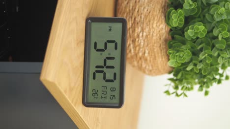 close-up of a digital clock displaying time, date, and temperature