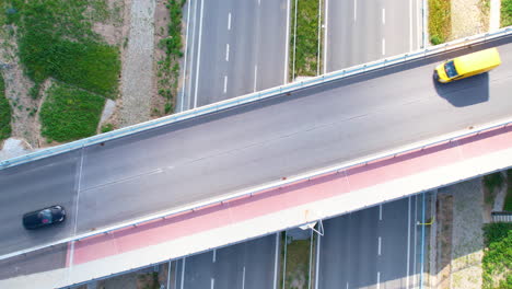 several cars and cans drive over a highway overpass, intersection