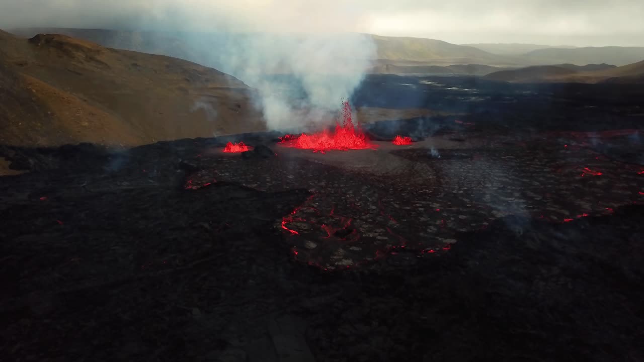 vista aérea del paisaje sobre el magma y la lava en erupción en el valle de meradalir, desde el volcán fagradalsfjall, con humo saliendo