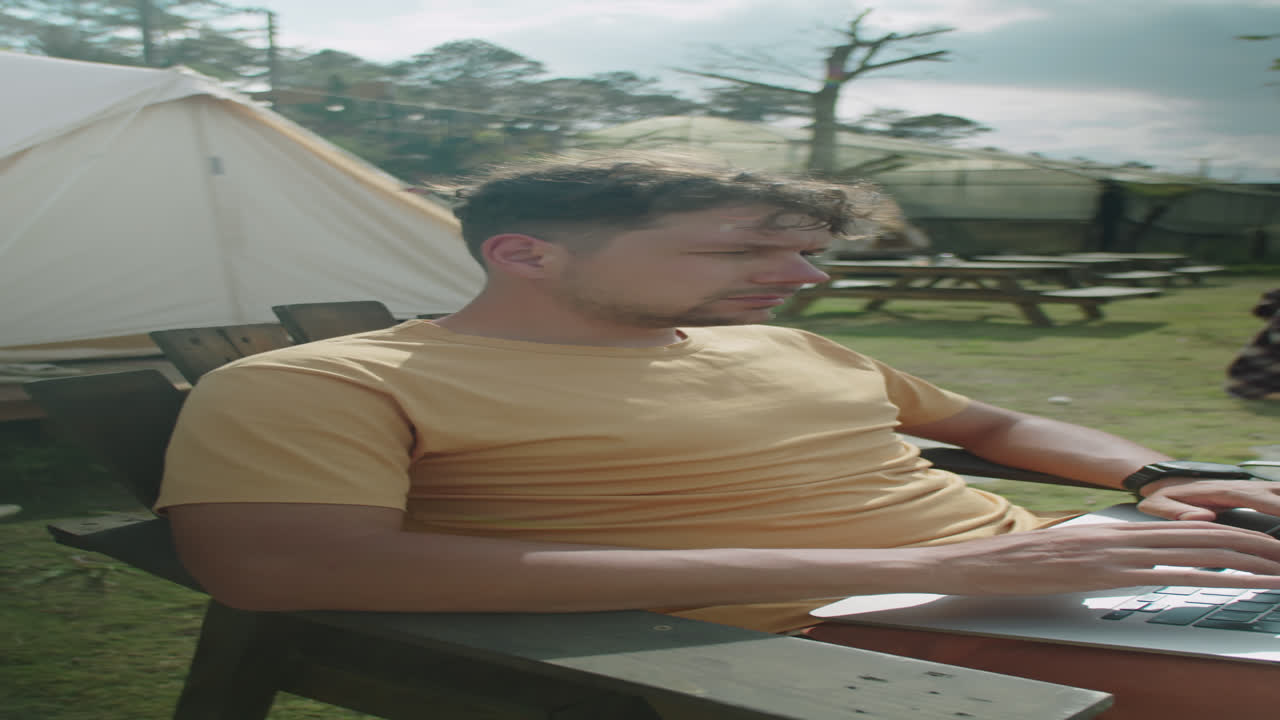 Man Working Laptop Outside of Glamping Tent