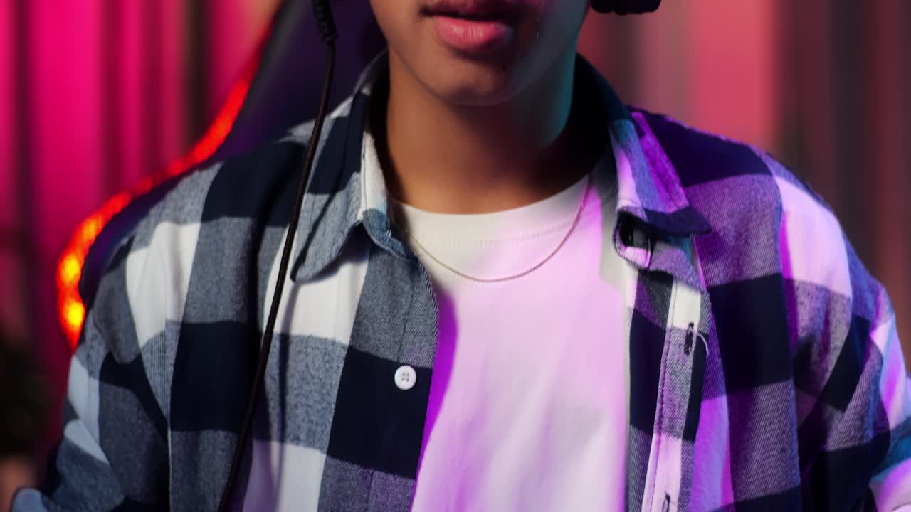 Close-up de jovem gamer asiático animado celebrando a vitória e dançando enquanto joga videogame no computador