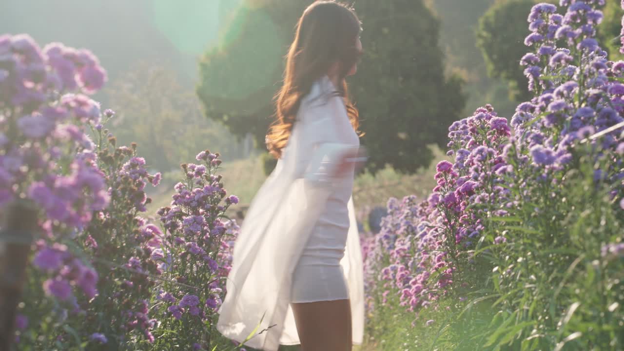 꽃에서 즐겁게 놀고 있는 행복한 태국 여자