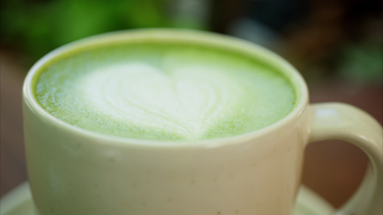 Close up of a heart latte art on a matcha latte