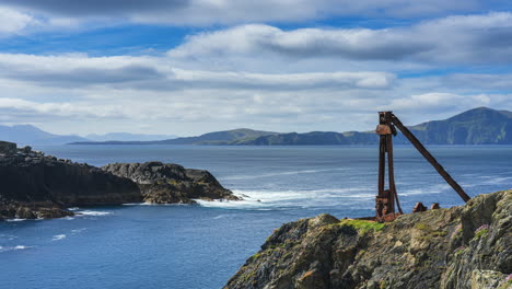 Timelapse-of-rugged-coastline-with-rust-covered-man-made-historical-construction-and-moving-clouds-on-sunny-day-in-Cloughmore-Bay-in-Achill-Island-in-county-Mayo-along-the-Wild-Atlantic-Way