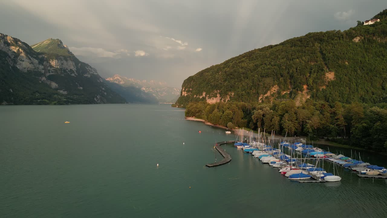 오른쪽에 파란색 차량의 보트 도크에 가기 위해 휴가를위한 멋진 장소의 새 전망과 다가오는 보트를 위해 노란색 빛이  ⁇ 박이는 충격적인 구름이  ⁇ 의 흐름을 생산하는 빛이 오는