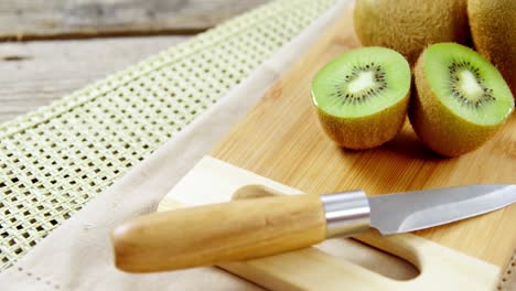 kiwi y cuchillo en la tabla de cortar