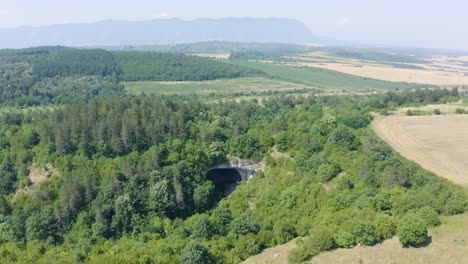 Drone-panning-from-the-right-to-the-left-side-of-the-frame,-showing-the-rock-arch-more-commonly-called-God's-Bridge,-located-near-Vratsa-in-Bulgaria